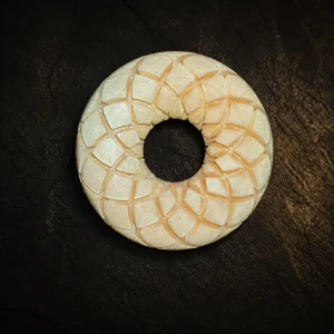 Pearl ivory Rodin coil on a dark studio surface